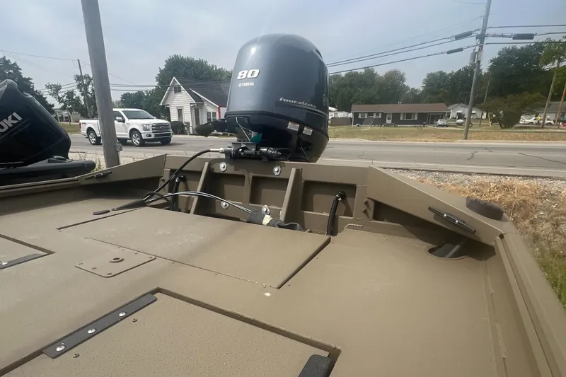 Slide: The Image of 2025 G3 Gator Tough 18 CCJ boat with 80 HP engine, parked near a road. - 11