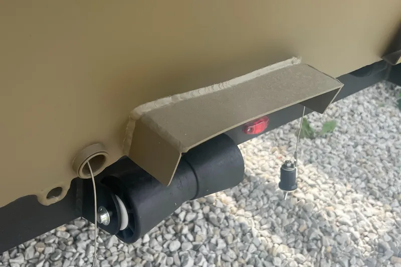 Slide: The Image of 2025 G3 Gator Tough 18 CCJ boat detail, featuring a metal component and wiring on gravel. - 13