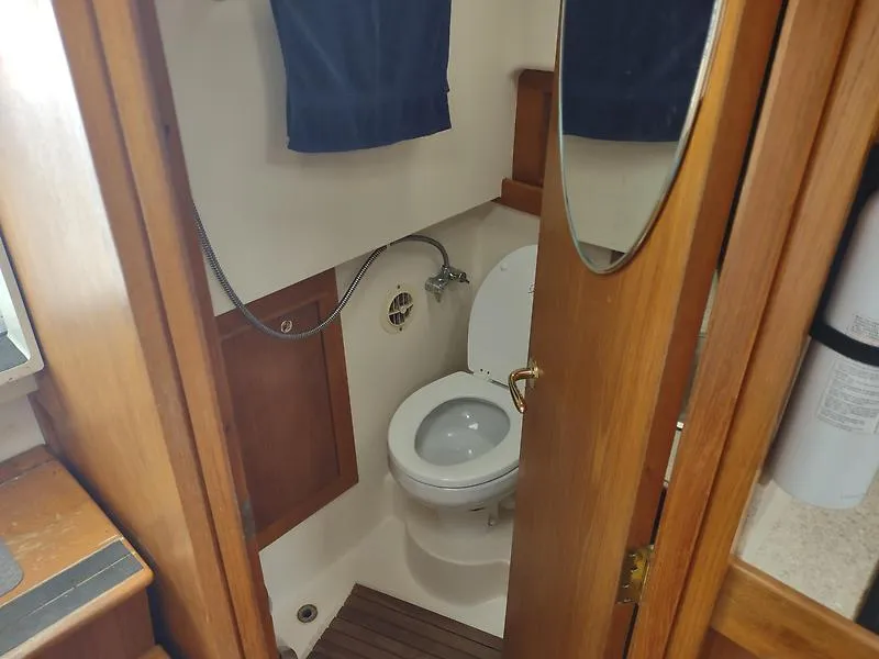 Slide: The Image of 2001 Mainship Pilot 34 Sedan bathroom with wooden accents and compact design. - 10
