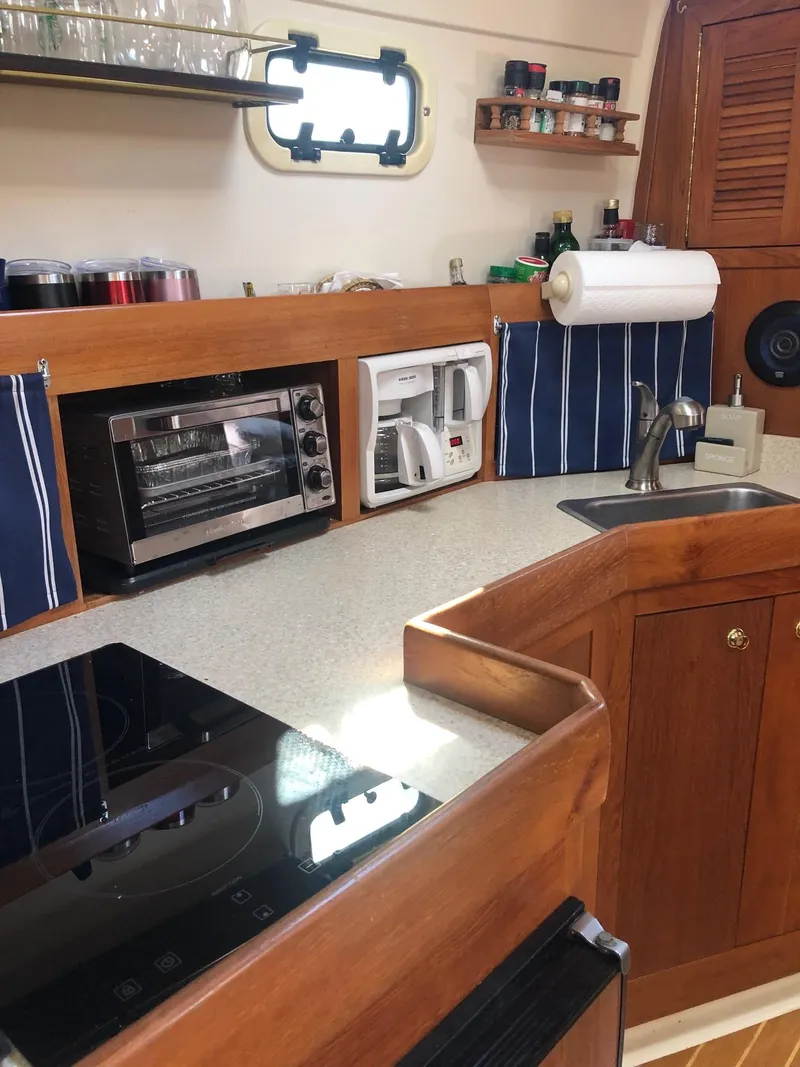 Slide: The Image of 2001 Mainship Pilot 34 Sedan kitchen with appliances and wooden cabinetry. - 11
