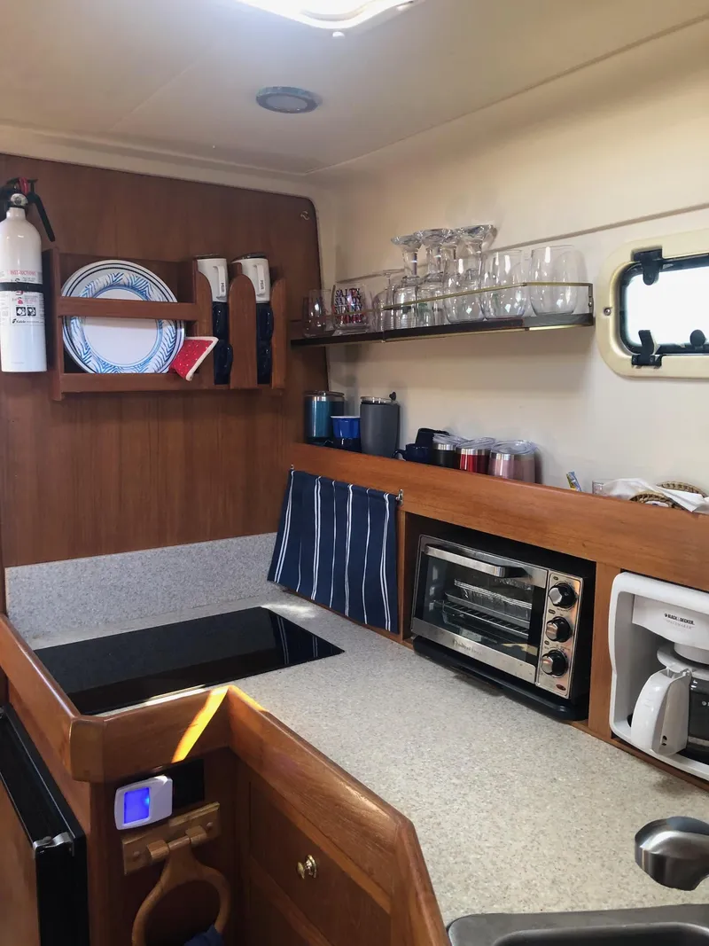 Slide: The Image of 2001 Mainship Pilot 34 Sedan kitchen with appliances and storage shelves. - 12