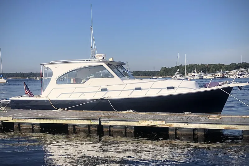 Slide: The Image of 2001 Mainship Pilot 34 Sedan docked at marina, clear sky, calm water. - 2