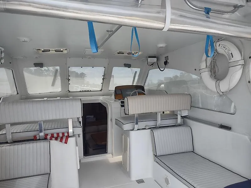 Slide: The Image of Interior of 2001 Mainship Pilot 34 Sedan with white seating and life preserver. - 4