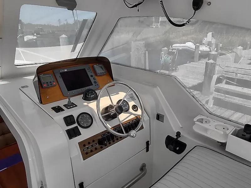Slide: The Image of 2001 Mainship Pilot 34 Sedan helm with steering wheel and navigation instruments. - 5