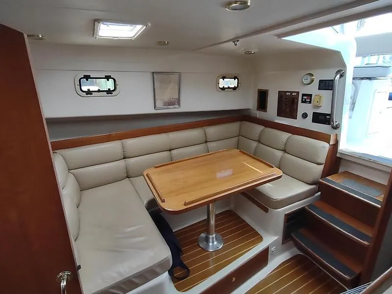Slide: The Image of 2001 Mainship Pilot 34 Sedan interior with cozy seating and wooden table. - 8