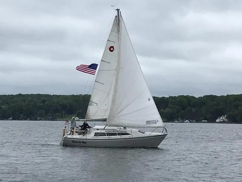 Slide: The Image of 1988 O'Day 27' LE sailboat on a lake, American flag, overcast sky. - 0