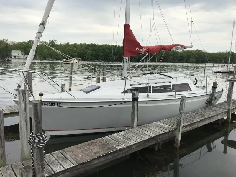 Slide: The Image of 1988 O'Day 27' LE sailboat docked on a calm lake with overcast sky. - 4
