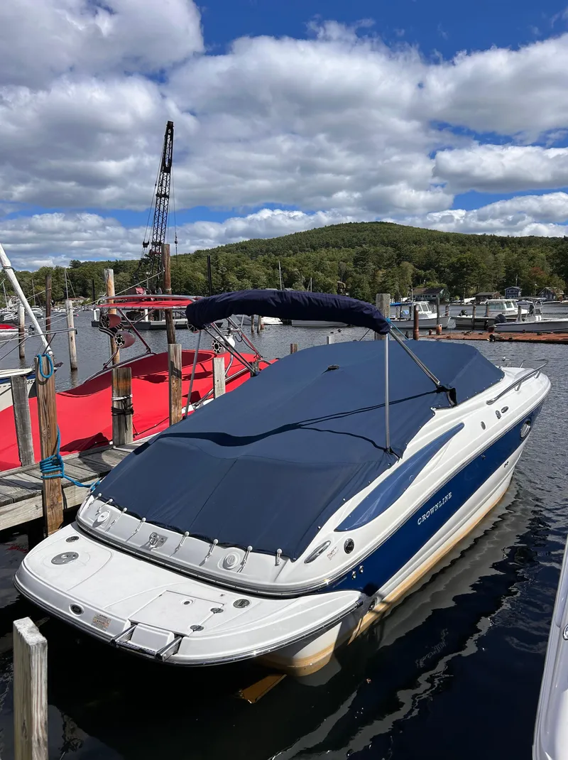 Slide: The Image of 2007 Crownline 255 CCR boat docked with blue cover, scenic lake view. - 2