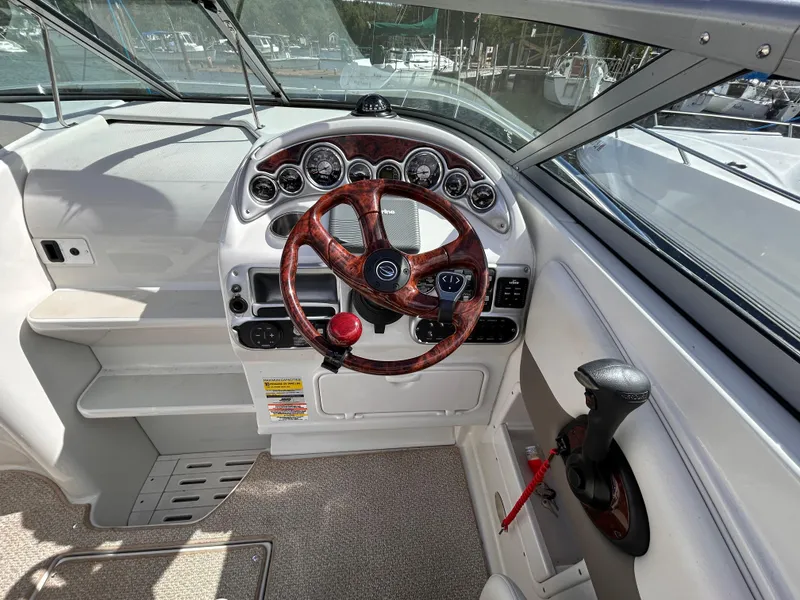 Slide: The Image of 2007 Crownline 255 CCR boat cockpit with wood-accented steering wheel and control panel. - 20