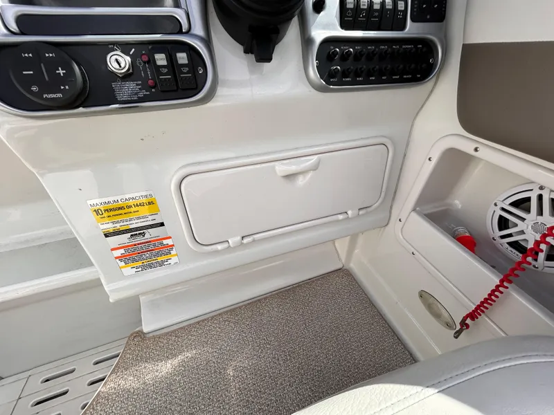 Slide: The Image of 2007 Crownline 255 CCR boat dashboard with control panel and storage compartment. - 24