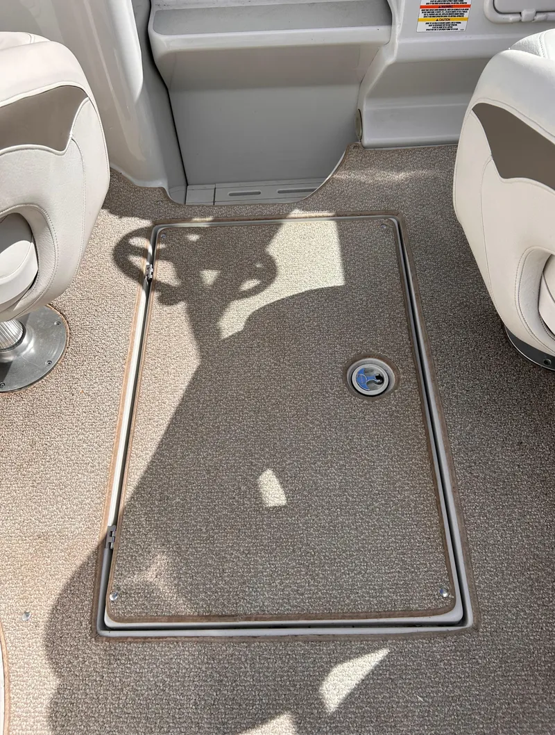Slide: The Image of 2007 Crownline 255 CCR boat interior with carpeted floor and storage hatch. - 26