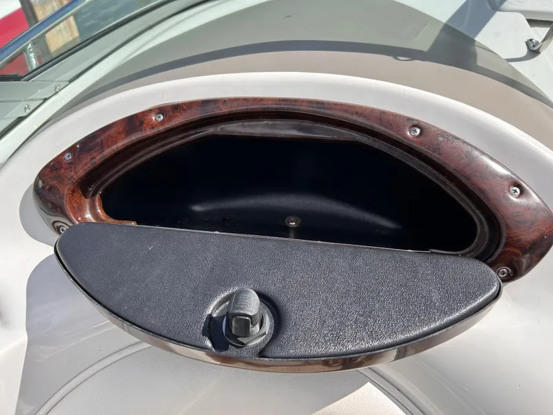 Slide: The Image of Crownline 255 CCR 2007 boat dashboard compartment with wood trim and latch. - 31