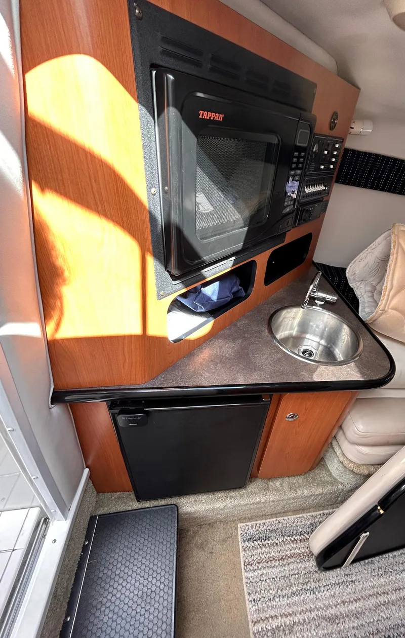 Slide: The Image of 2007 Crownline 255 CCR boat interior with kitchenette, microwave, sink, and mini-fridge. - 42