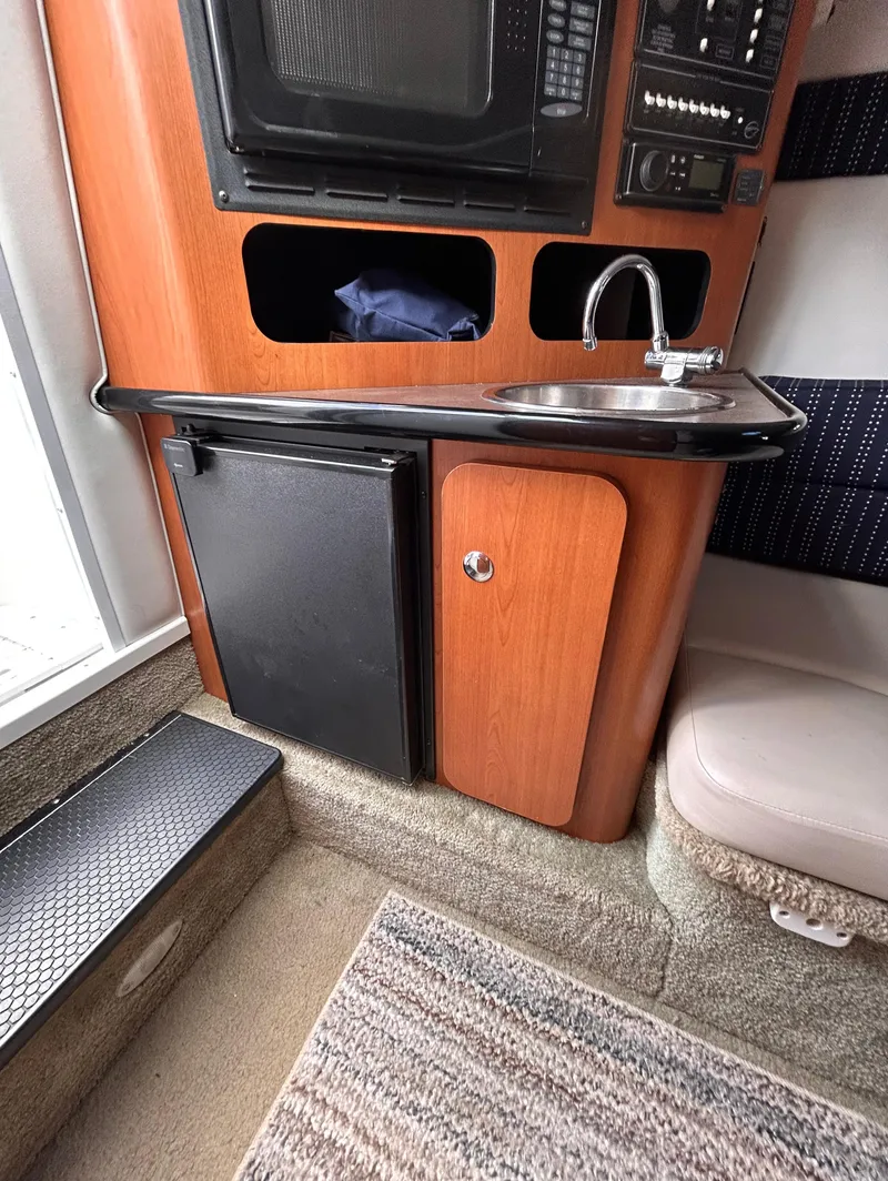Slide: The Image of 2007 Crownline 255 CCR boat interior with kitchenette, sink, and mini fridge. - 45