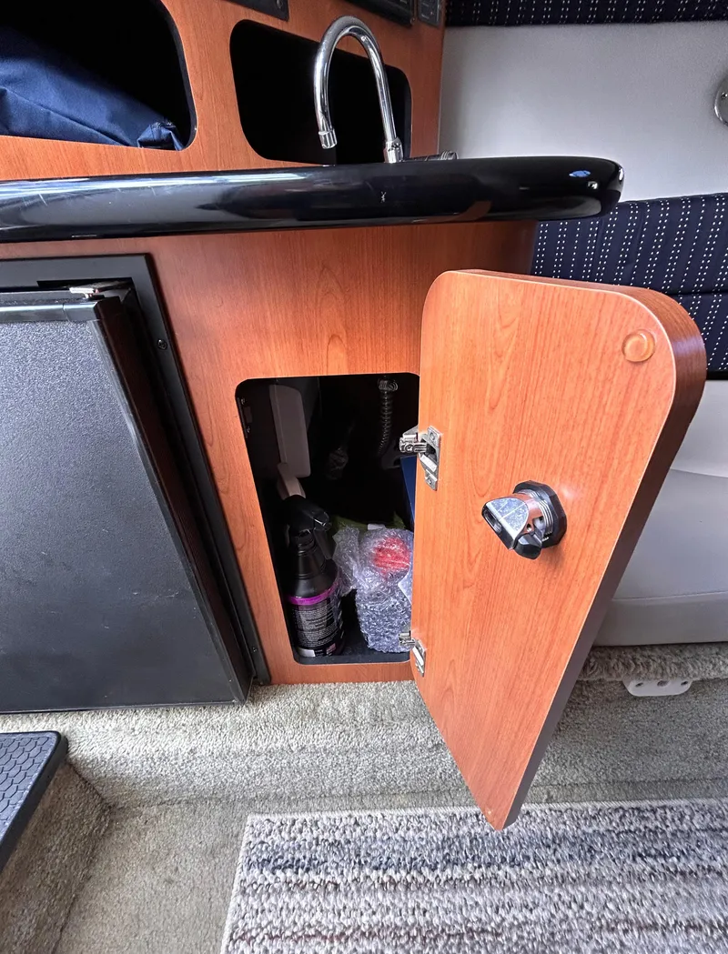 Slide: The Image of 2007 Crownline 255 CCR cabin interior with open wooden cabinet and sink. - 46