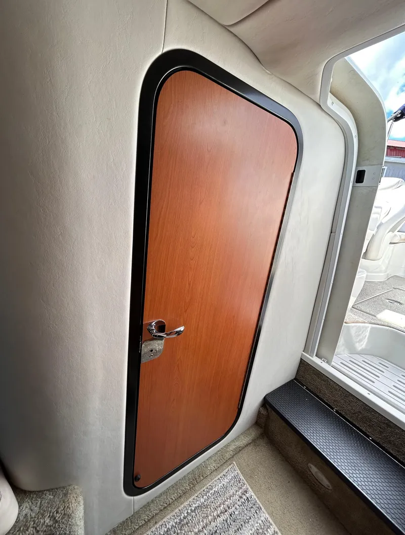 Slide: The Image of 2007 Crownline 255 CCR cabin door with wood finish and modern design. - 48