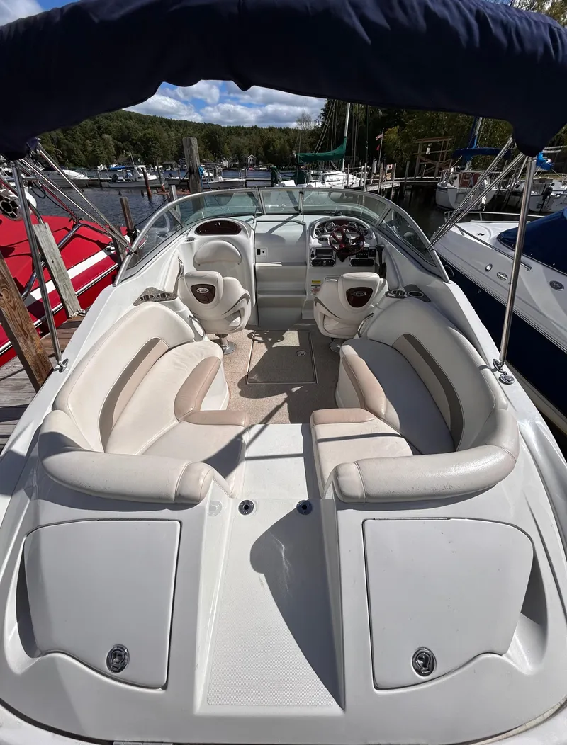 Slide: The Image of 2007 Crownline 255 CCR boat interior with seating and steering wheel, docked at marina. - 8
