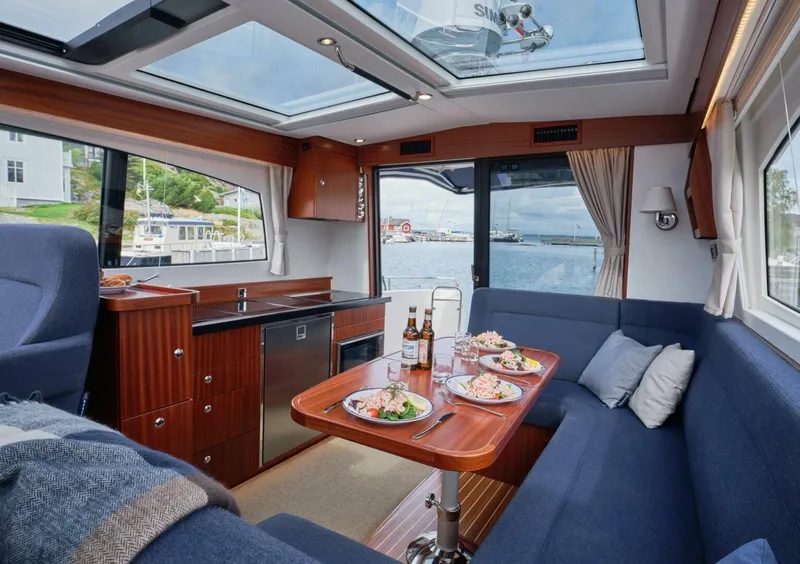 Slide: The Image of Luxurious interior of 2024 Nimbus 405 Coupé yacht with dining setup and scenic view. - 4