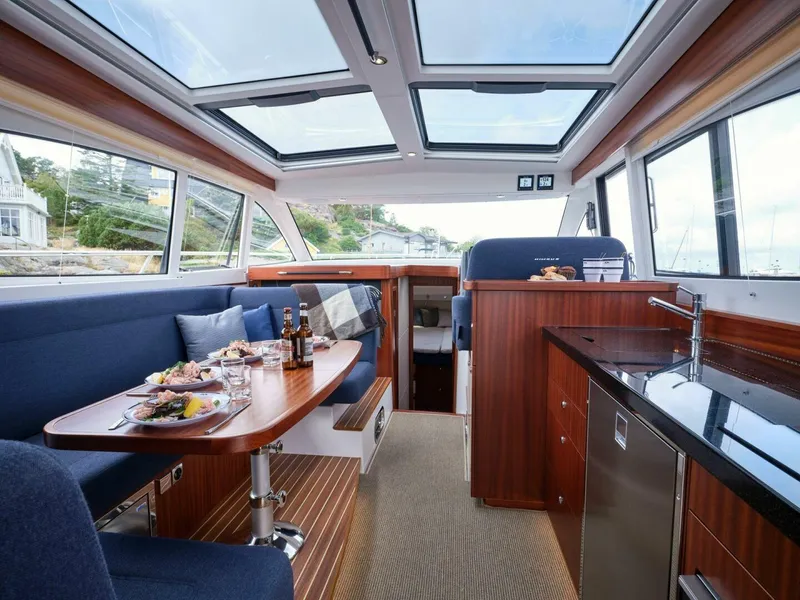 Slide: The Image of Luxurious interior of 2024 Nimbus 405 Coupé yacht with dining area and kitchenette. - 5