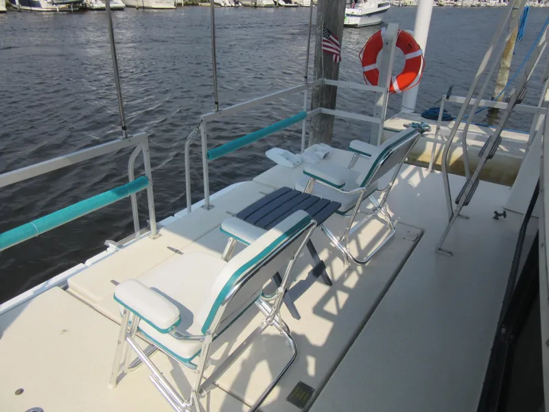 Slide: The Image of Deck of 1995 Gibson 44 Classic boat with chairs and life preserver by the water. - 14