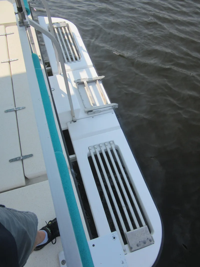 Slide: The Image of 1995 Gibson 44 Classic boat deck with metal railings and water view. - 15