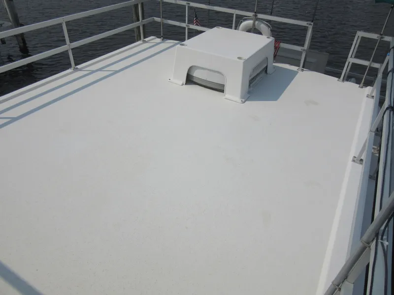 Slide: The Image of Rooftop deck of a 1995 Gibson 44 Classic boat with railing and vent. - 17