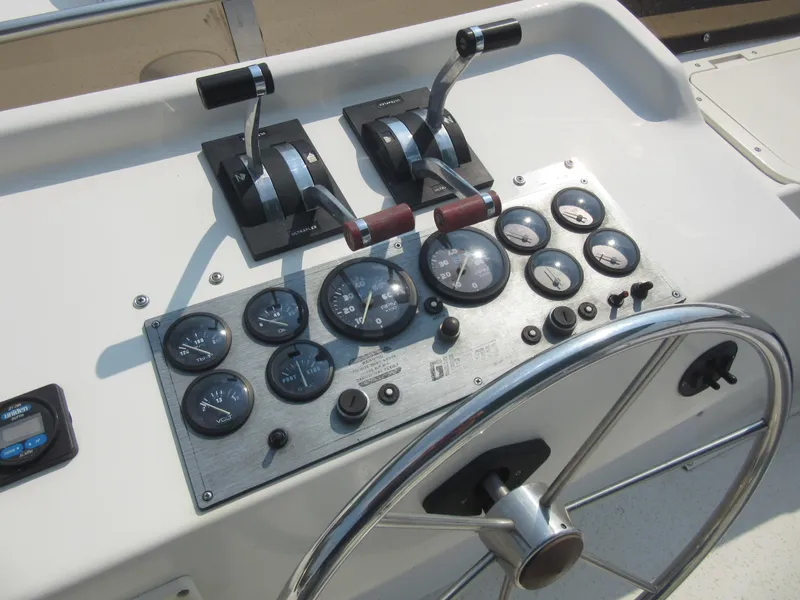 Slide: The Image of Control panel of a 1995 Gibson 44 Classic boat with gauges and steering wheel. - 23