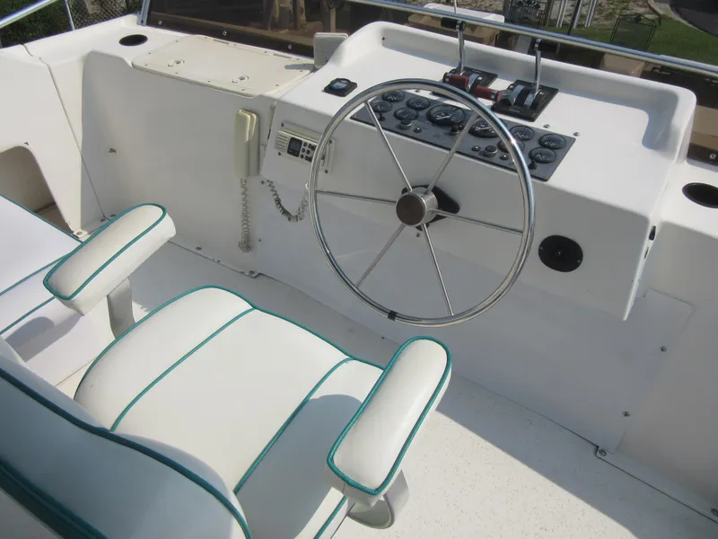 Slide: The Image of 1995 Gibson 44 Classic boat helm with white seating and steering wheel. - 24