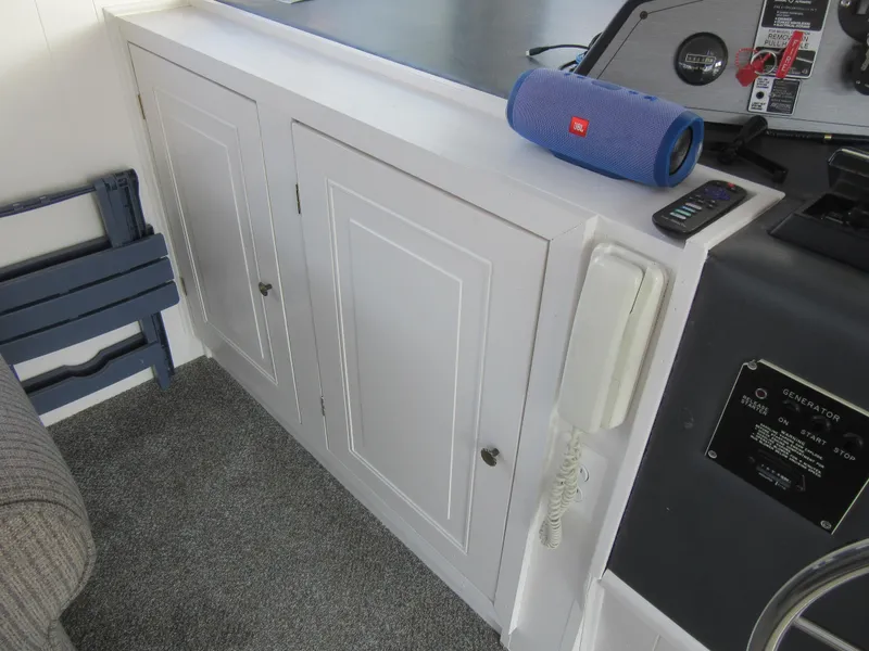 Slide: The Image of White cabinet with blue speaker and phone on a 1995 Gibson 44 Classic boat. - 28