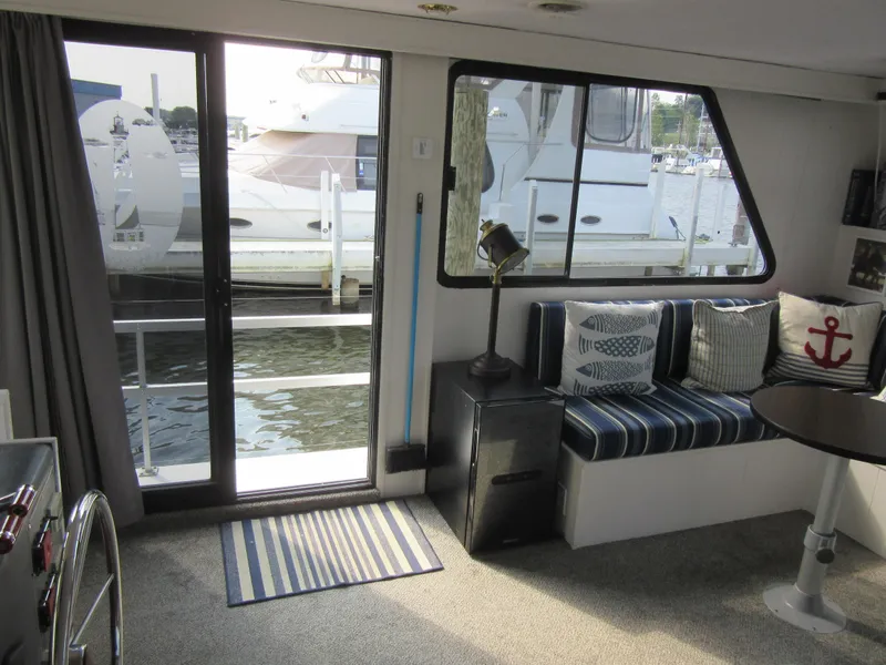 Slide: The Image of Interior of 1995 Gibson 44 Classic boat with marina view, striped seating, and nautical decor. - 31