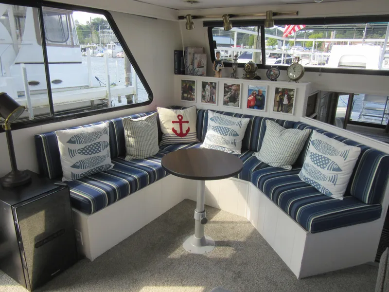 Slide: The Image of Cozy boat interior with striped seating, nautical pillows, and round table on a Gibson 44 Classic. - 33