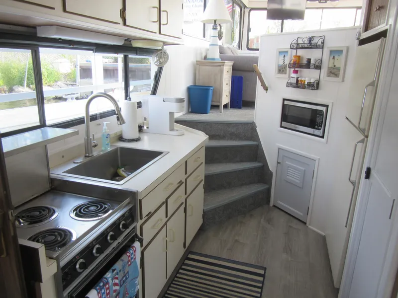 Slide: The Image of Gibson 44 Classic 1995 boat kitchen with stove, sink, and microwave. - 37