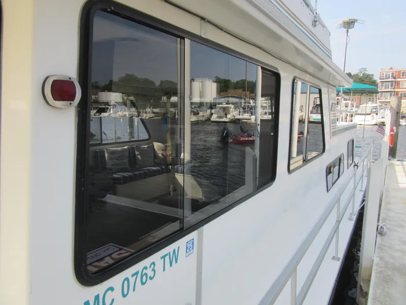 Slide: The Image of Side view of a 1995 Gibson 44 Classic houseboat docked at a marina. - 7