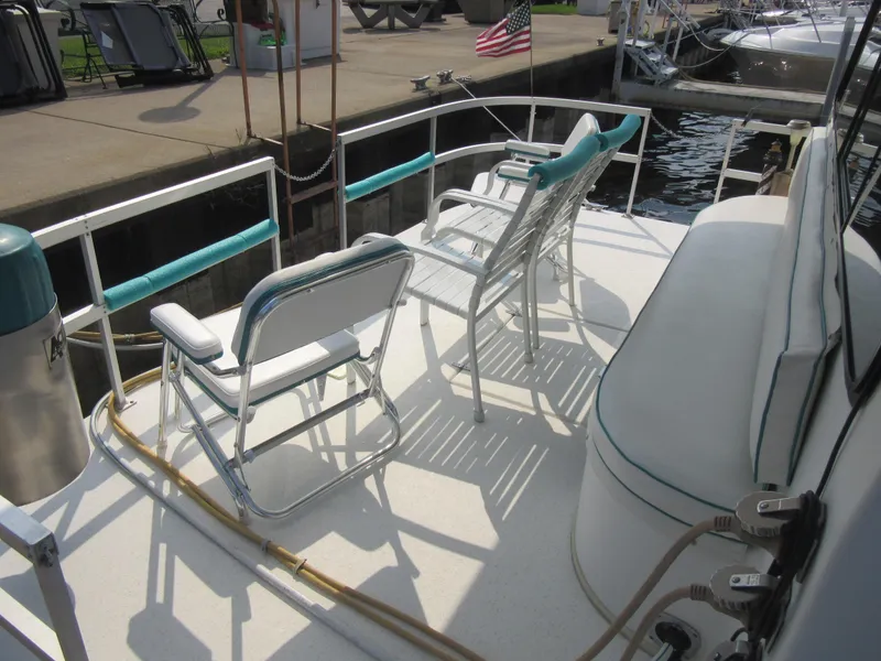 Slide: The Image of Deck of 1995 Gibson 44 Classic boat with chairs and American flag. - 8