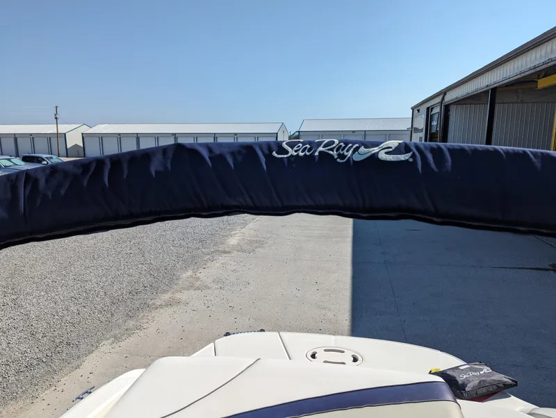 Slide: The Image of 2006 Sea Ray 200 Select boat with blue cover in a marina setting. - 26