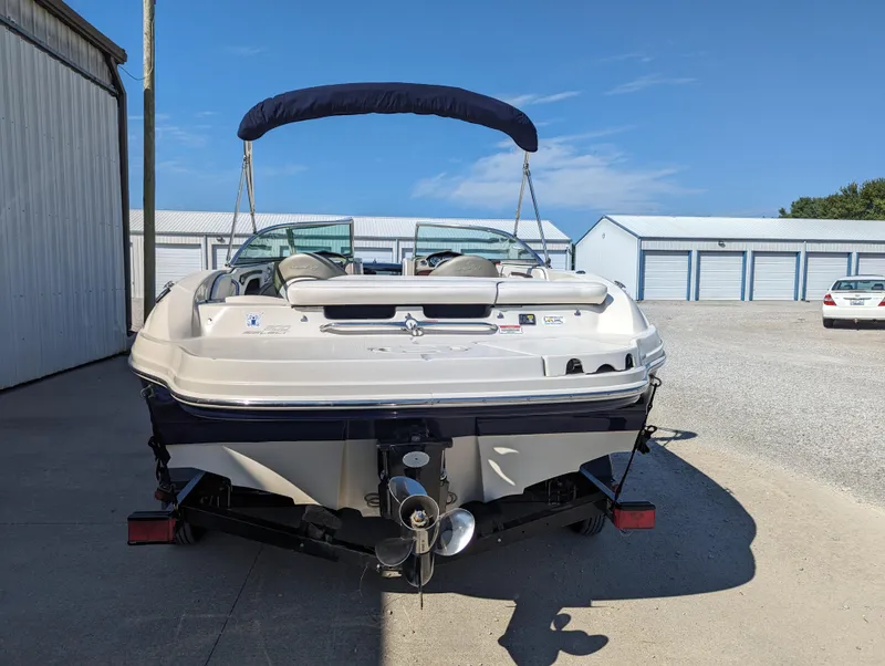 Slide: The Image of 2006 Sea Ray 200 Select boat, rear view, parked outdoors near storage units. - 4