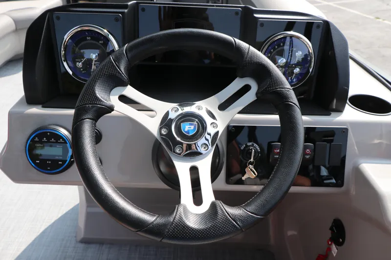 Slide: The Image of Steering wheel of 2025 Premier 220 Sunscape boat with dashboard controls. - 12
