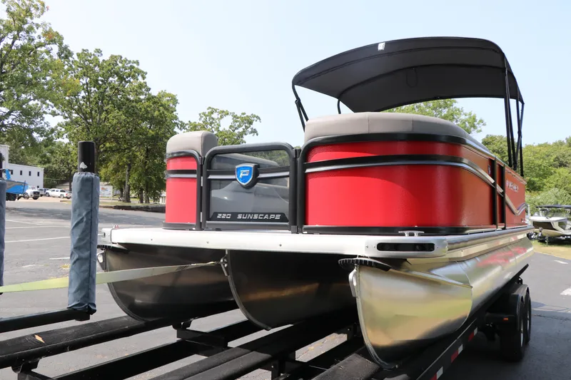 Slide: The Image of 2025 Premier 220 Sunscape pontoon boat on trailer, red exterior, parked outdoors. - 6