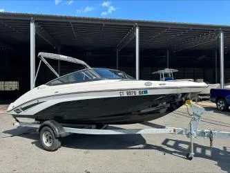 Slide: The Image of 2019 Yamaha Boats SX195 on trailer, parked outdoors under a metal canopy. - 2