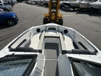 Slide: The Image of 2019 Yamaha Boats SX195 interior with seating and storage, parked in a marina. - 22