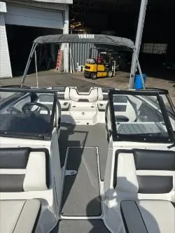 Slide: The Image of 2019 Yamaha SX195 boat interior with seating and windshield in a warehouse setting. - 24