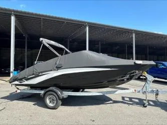 Slide: The Image of 2019 Yamaha SX195 boat on trailer, covered and parked outdoors. - 25