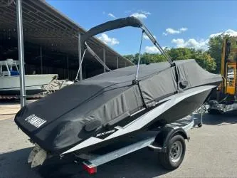 Slide: The Image of 2019 Yamaha SX195 boat on trailer with cover, parked outdoors. - 26