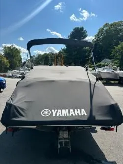 Slide: The Image of 2019 Yamaha SX195 boat with cover, parked outdoors under a clear blue sky. - 27