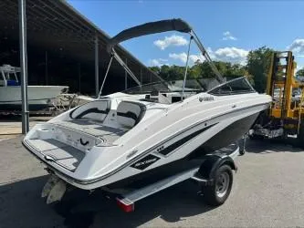 Slide: The Image of 2019 Yamaha SX195 boat with trailer, parked outdoors under a clear sky. - 7