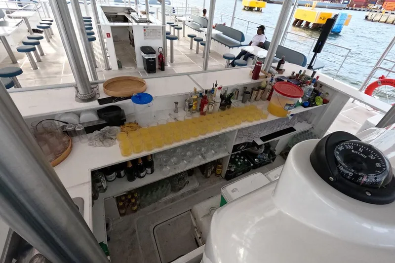 Slide: The Image of Boat bar setup on Custom PaxCat 80, 2024, with drinks and seating by the water. - 14