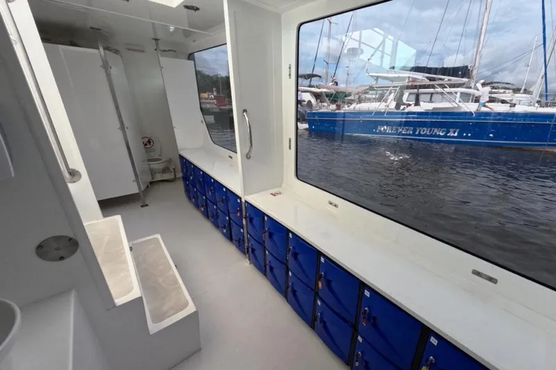 Slide: The Image of Interior of 2024 Custom PaxCat 80 boat with blue storage lockers and large windows. - 19