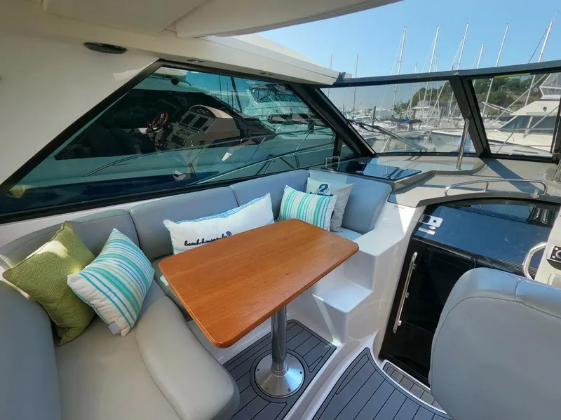 Slide: The Image of Interior of 2011 Regal 42 Sport Coupe with cozy seating and wooden table. - 11