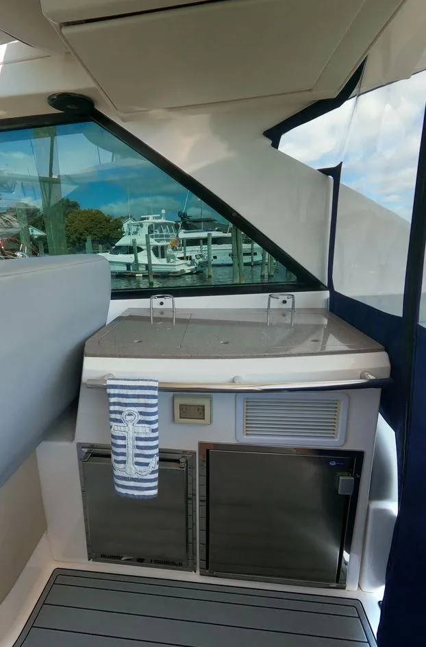 Slide: The Image of 2011 Regal 42 Sport Coupe yacht interior with kitchenette and marina view. - 14