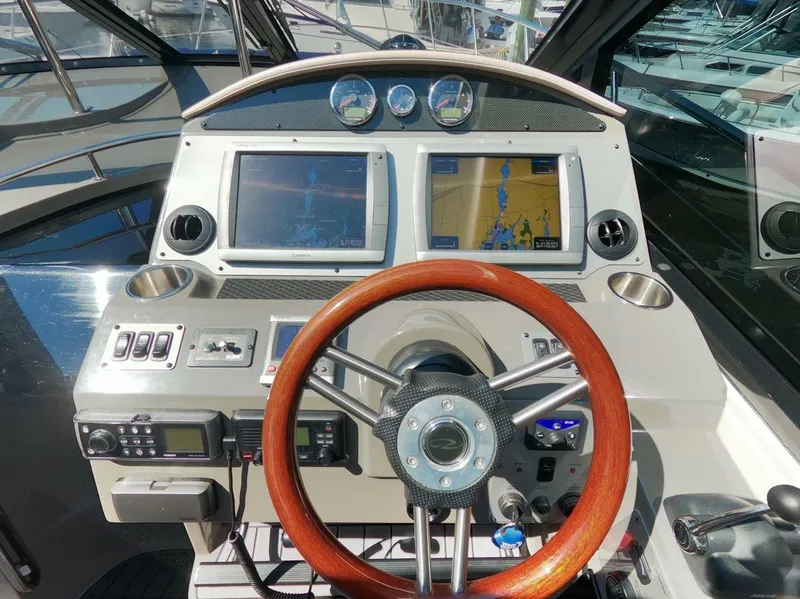 Slide: The Image of 2011 Regal 42 Sport Coupe helm with dual navigation screens and wooden steering wheel. - 15